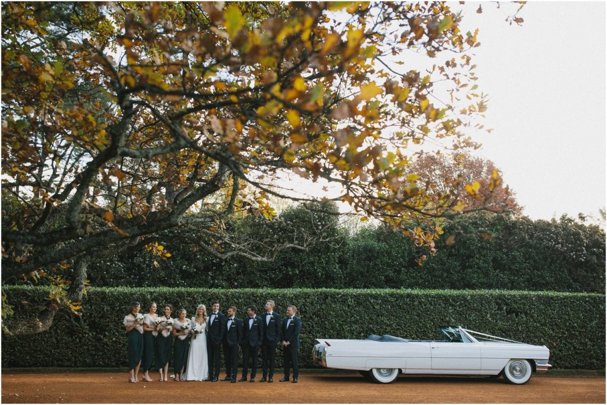 Bridal party pose next to a Cadillac at Bendooley Estate