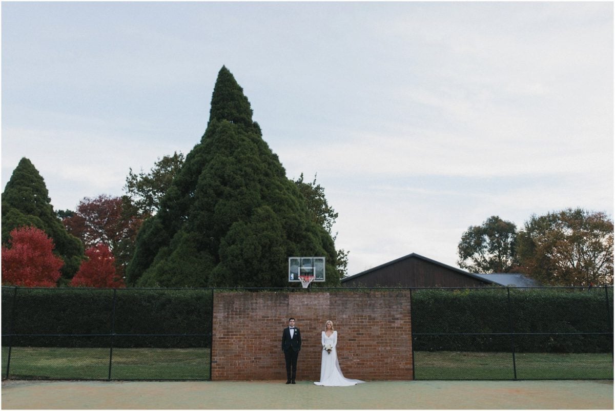 Bride and groom at Bendooley Estate in front of a basketball hoop