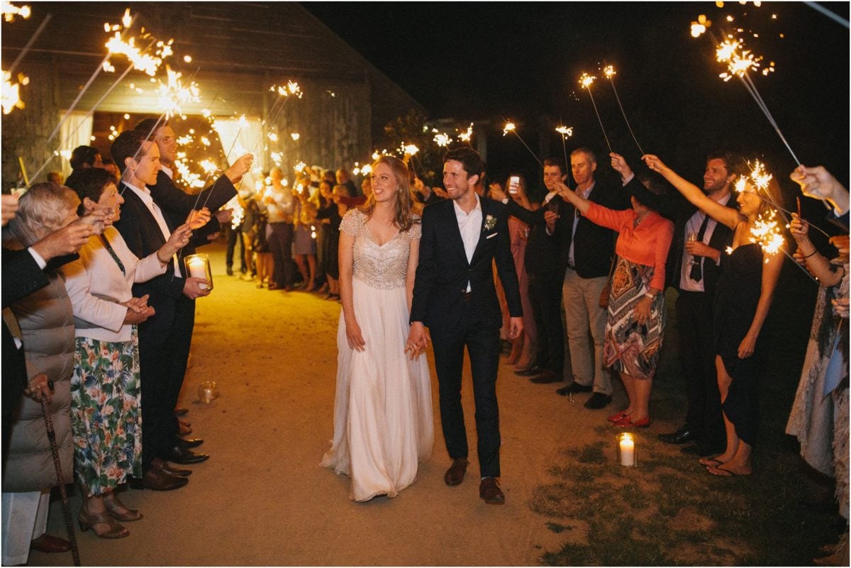 A bride and groom walk through an aisle of sparklers at the end of their Aghadoe Estate wedding reception