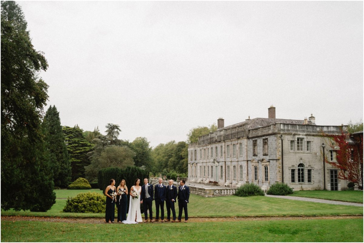 A bridal party stand on the grass at an incredible Gloster House wedding in Ireland